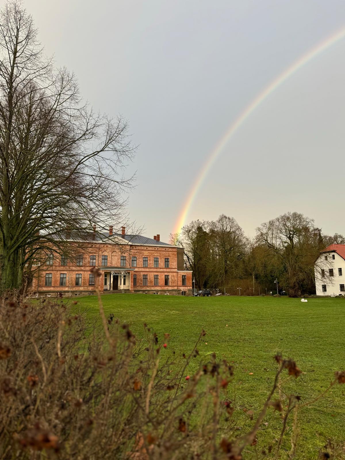Farbenfroher Regenbogen über der ländlichen Landschaft nach einem Regenschauer